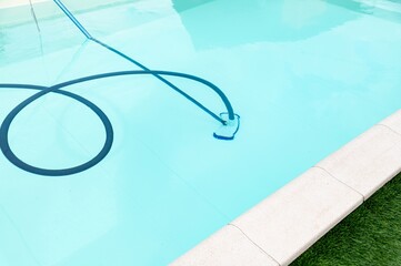 Pool maintenance in a residential backyard with clear blue water on a sunny day