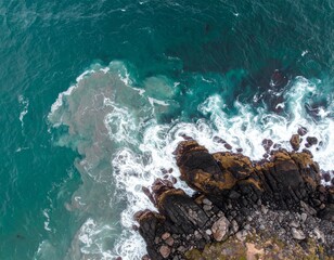 Aerial View of Dark Rocks and Turquoise Ocean Waves Crashing on Coastline