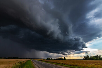 WEATHER Dramatic black rain clouds over fields and country road