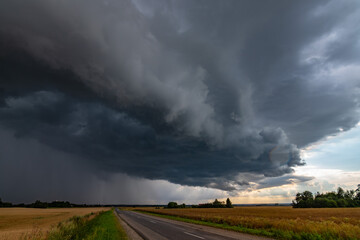 WEATHER Dramatic black rain clouds over fields and country road