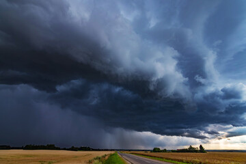 WEATHER Dramatic black rain clouds over fields and country road