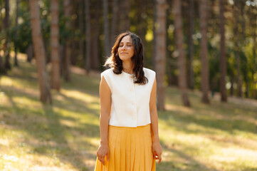 A serene and peaceful portrait of a woman joyfully enjoying the beauty of nature in a sunlit forest setting