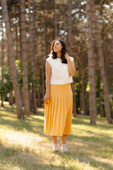 A young woman is enjoying the serene and beautiful wonders of nature while wearing a stylish and bright yellow outfit
