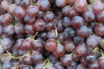 Closeup of vibrant red grape texture a sweet and juicy symphony of natures candy and natural deliciousness. Luscious red grapes overflowing a rustic basket a bountiful autumn harvest.