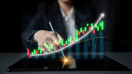 A business professional evaluates financial trends using a stylus on a tablet. The image features...