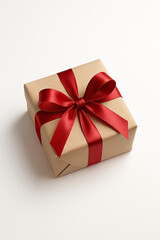 Obraz premium Classic Christmas gift box wrapped in kraft paper and red ribbon isolated on white background soft shadows studio product photo holiday e-commerce