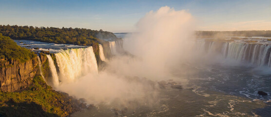 Soft focus view of waterfall blurred in distance through fog with golden backlight