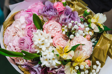 Flower arrangement background. Mixed bouquet of various types of flowers and colors. Delicate pink peonies and roses wih yellow alstroemeria bordered wiht gypsophila.