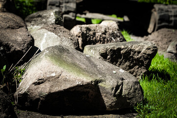 Obraz premium close-up of large boulders in a yard with construction equipment in the background used for retaining walls, erosion control, and foundations. slope stabilization and soil conservation