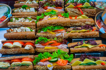 Freshly prepared gourmet sandwiches arranged neatly with vibrant vegetables and toppings