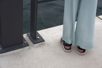 Person in Light Blue Pants by Waterfront