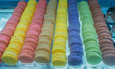 Colorful macarons displayed in a bakery showcase, showcasing vibrant hues and tempting textures