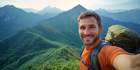 Man smiling on mountain top with gear.