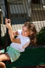 Smiling Girl Enjoying Outdoor Playground Activity on a Sunny Day
