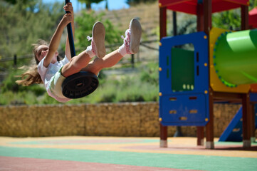 Young Girl Enjoying Playground Swing on a Bright Summer Day