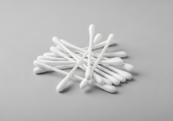 Pile of white cotton swabs isolated on a grey background
