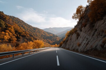 Road through scenic autumn mountain landscape with vibrant foliage and clear sky