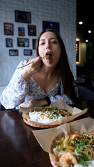 Close-up of Caucasian woman eating pan-Asian cuisine