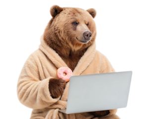 A brown bear wearing a bathrobe holding a donut while using a laptop on a black background shot