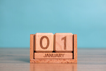 Wooden perpetual calendar showing january 1st on turquoise background