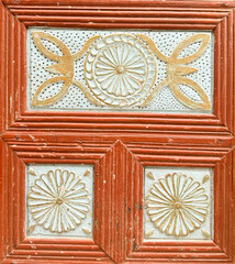 Intricate wooden door design featuring floral patterns and rich colors in a historic location