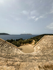 Ancient amphitheater with ocean view near olive trees on a sunny day