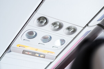 Fototapeta premium Brightly lit control panel for passenger seat in airplane cabin interior