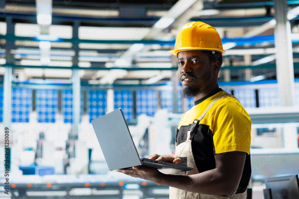 Poster man engineer in photovoltaics factory uses tracking software on pc to diagnose malfunctioning system