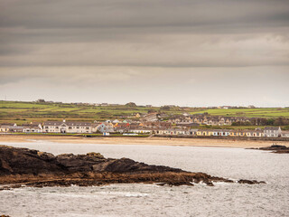 Rough stone coastline, ocean and beautiful white houses of Kilkee town in county Clare, Ireland....