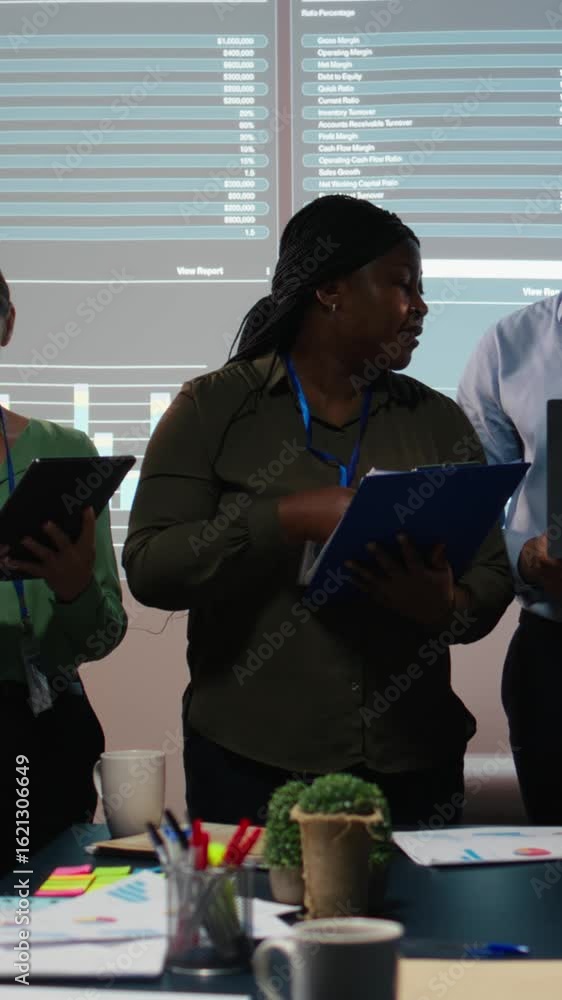 Poster vertical video portrait of multiethnic business team collaborating late at night, assembling in a da