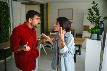 Young couple arguing about online shopping and credit card expenses at home