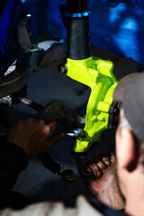 Installing racing disc brake with vibrant green knuckle on suspension. Front Suspension and Brake Disc Installation. Installing performance suspension and brake disc for drift control and braking.
