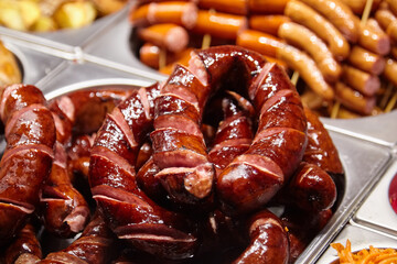 Juicy, grilled sausages arranged in a display, showcasing a variety of textures and colors, with a focus on the rich, glistening surface and appetizing presentation of the meat