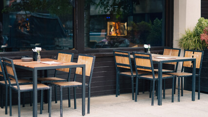 Outdoor cafe with simple chairs and tables on a sunny day in city street view