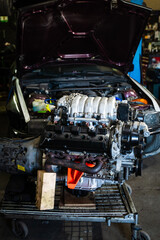 Engine swap in action featuring intake and transmission. Engine Swap in Progress. Custom V8 engine prepared for installation in drift car. Highlighting headers, intake, and pulley system.