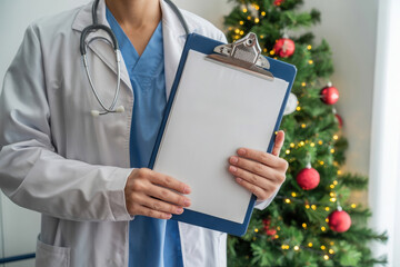 Healthcare professional holding navy blue clipboard Christmas tree in background, medical holiday scene