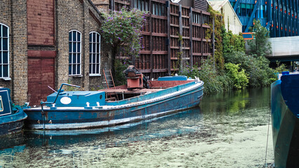 Vintage boats moored on calm canal water in charming English Little Venice town