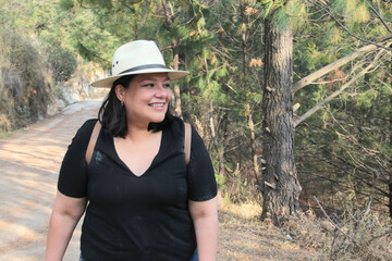 A 40-year-old Latina woman hikes in the mountains to fully enjoy nature and sunlight, experiencing well-being and empowerment