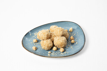 Homemade sweet hazelnut balls covered in crumbs, served on a plate. Isolated on white background