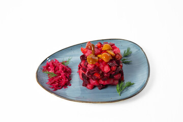 Traditional Russian salad "Vinaigrette" with pickled mushrooms and sauerkraut, served on a plate with fresh dill. Isolated on white background