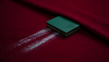 Green box on red fabric with glitter trail