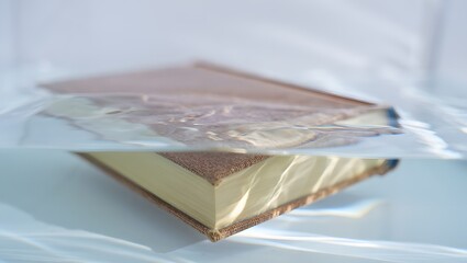 Ancient book submerged in clear water with visible pages