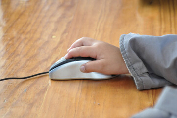 Child's hand using mouse in computer class