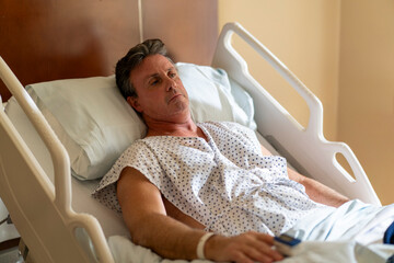 Hospitalized man monitoring oxygen levels in bed