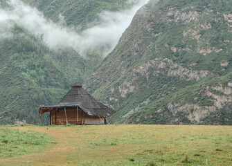 A quaint wooden cabin nestled in a beautiful mountain valley, surrounded by nature.