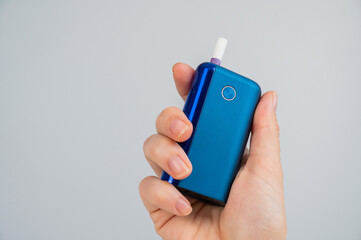 Woman holding electronic cigarette on white background. Tobacco heating systems.