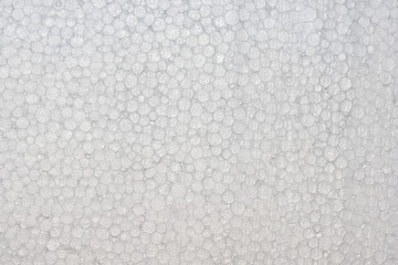 Close-up texture of white expanded polystyrene foam with round air cells. Lightweight insulation material background used in packaging, construction, and thermal protection. EPS surface macro detail.