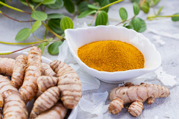 Fresh and Ground Turmeric Root on Rustic Background