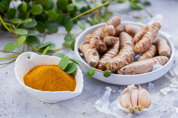 Fresh and Ground Turmeric Root on Rustic Background