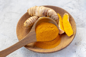Fresh and Ground Turmeric Root on Rustic Background